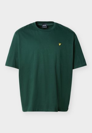 Temno zelena bombažna majica s kratkimi rokavi, okroglo izrezom in majhnim rumenim logotipom ptice, vezenim na levi strani prsnega koša.