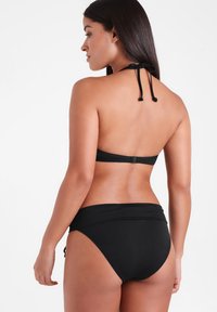 Ensemble de bikini noir comprenant un haut à col halter et un bas taille haute. Fabriqué dans un tissu lisse avec un design simple et sans coutures.
