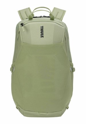 Sac à dos Thule vert clair avec bretelles rembourrées, poignée supérieure, compartiments zippés et panneau avant en mesh respirant.