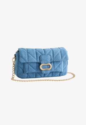 Pochette en denim bleu clair matelassé avec fermoir ovale doré et chaîne dorée, présentée sur fond blanc.