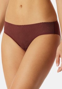 Burgundské dámske spodné prádlo s bezšvovým dizajnom a jemným vlnkovým vzorom, s volánovým pásom. Vyrobené z jemnej a elastickej tkaniny.