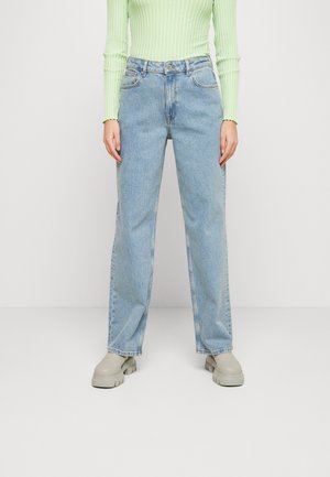 Lichtblauwe, hoogopgesneden jeans met een rechte pasvorm. De denim heeft een vervaagde was en een klassiek vijf-pocket ontwerp, gedragen met beige schoenen.