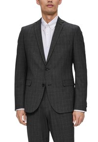 Szary garnitur w kratę z klapami typu notch, na dwa guziki i slim fit. Połączony z białą koszulą, z klasycznym kołnierzykiem.