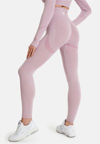 Lilac leggings med hög midja, med texturerade paneler och ribbade detaljer. Kombineras med vita sneakers för en komplett look.