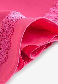 Fuchsia-Stoff mit strukturiertem Spitzenbesatz, glatter Textur und gerollten Kanten, der eine helle, lebendige Farbe zeigt.
