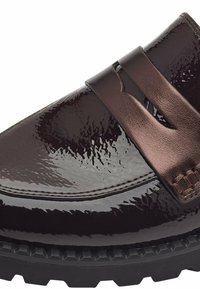 Chaussure marron en cuir verni à enfiler avec une large sangle et une semelle en caoutchouc noir texturée. Surface lisse et brillante avec des détails de couture subtils.