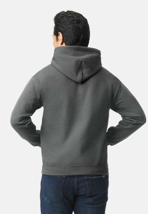 Grijze hoodie met een zachte textuur. Voorzien van een kangoeroezak en ribgebreide manchetten. Draagt over donkere spijkerbroeken, gezien vanuit de achterkant.