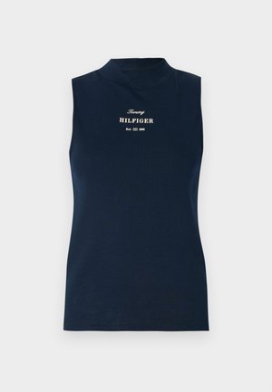 Marineblå ermeløs topp med høy hals, laget av mykt stoff. Har "Tommy HILFIGER"-logo i gull og etableringsår under.