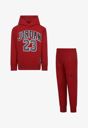Rode hoodie met "Jordan" en "23" gedrukt in zwart en wit, gecombineerd met bijpassende rode sweatpants voorzien van een zwart logo-detail.