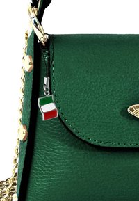 Groene, gestructureerde leren handtas met een gouden kettinghengsel. Bevat een zilveren Italiaanse vlag charm en gouden hardware accenten.