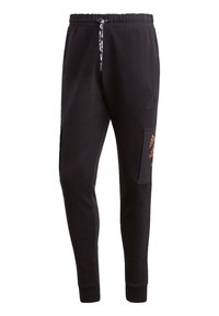 Černé zužující se tepláky s elastickým pasem, maskáčovou stahovací šňůrkou, boční kapsou na cargo a nenápadnými logy Adidas.