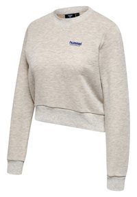 Sweatshirt court gris clair en tissu doux, avec un col rond, des poignets côtelés et un logo "hummel" bleu sur la poitrine.