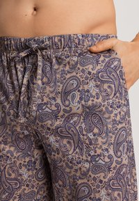 Lehké bavlněné kalhoty s paisley potiskem v odstínech modré a fialové. Mají elastický pás se stahovací šňůrkou a boční kapsy.