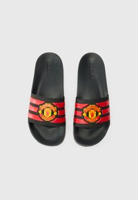 Black slide sandals with three red stripes and a Manchester United logo on the strap; textured footbed for comfort.