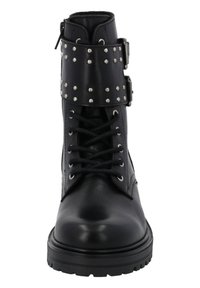 Botas negras de tobillo con un acabado de cuero texturizado, con cordones en la parte frontal y una correa con tachuelas alrededor del tobillo. Suela de goma gruesa.