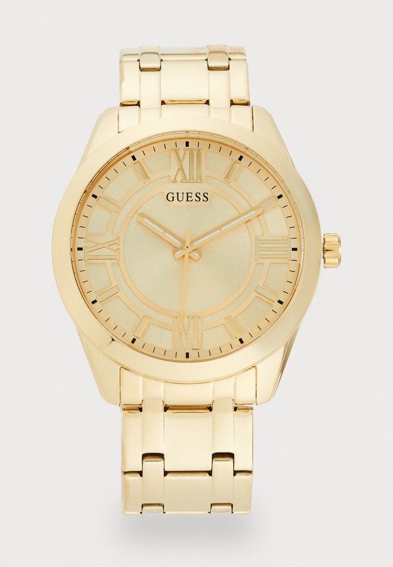 Gold watch with a metallic band, featuring a round case, Roman numeral hour markers, and a minimalist dial with simple hands.