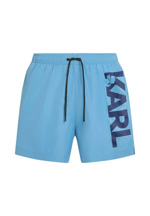 Lichtblauwe zwemshorts met elastische tailleband, zwarte trekkoord en grote verticale marineblauwe "KARL" tekst op het rechterbeen.
