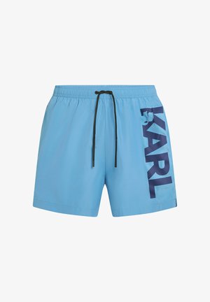 Lichtblauwe zwemshorts met elastische tailleband, zwarte trekkoord en grote verticale marineblauwe "KARL" tekst op het rechterbeen.