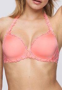 Vaaleanpunainen rintaliivi, jossa on pehmustetut kupit ja pitsikoristelu. Hihnoissa on kukkakoristeita ja pieniä nauhoja. Liukas pinta ja hyvin istuva muotoilu.