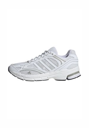 Zapatilla deportiva blanca con parte superior de malla, cierre de cordones, tres franjas laterales y suela acolchada con detalles en negro en la suela exterior.