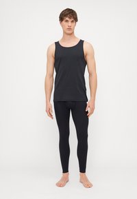 Μαύρη μπλούζα και κολάν, κατασκευασμένα από μαλακό και ελαστικό υλικό. Η μπλούζα έχει στρογγυλή λαιμόκοψη και τα κολάν έχουν εφαρμοστή σχεδίαση.