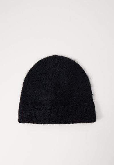 Mustast villast beanies, mis on valmistatud pehmest materjalist, ümmarguse tipuga ja volditud äärisega, et lisada tekstuuri ja soojust.