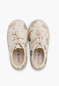 Scarpe in tela beige con un motivo di animali giocoso, dotate di un classico design con lacci, superficie morbida al tatto e suole tonde in gomma.