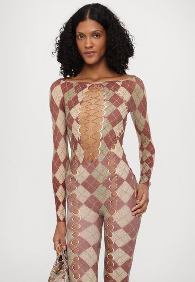 Rødrutete jumpsuit i argyle-mønster med beige og grønn. Har lange ermer, utskjæringer langs sidene og en dyp utringning. Glatt tekstur.