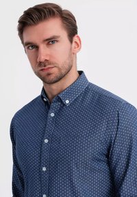 Navyblauw overhemd met knoopsluiting en een klein ankerpatroon, met een button-down kraag en borstzak, gemaakt van textuurstof.