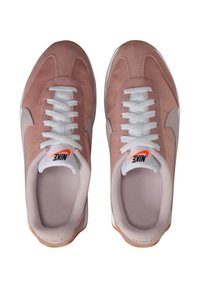 Zapatillas de ante y malla rosas con cordones blancos y logo de swoosh en el lateral. Suela acolchada y cuello acolchado para mayor comodidad.