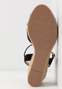 Semelle de sandale avec semelle à motif, bord en jute tressé de style espadrille, lanières noires, boucle et marquage Stuart Weitzman en taille 37.