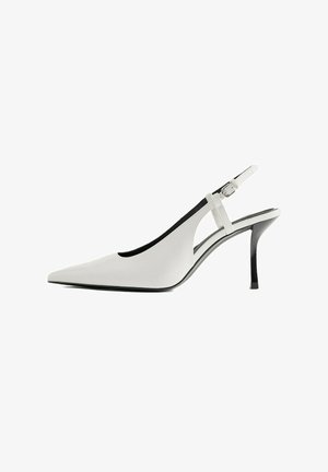 Witte pumps met spitse neus, een dunne zwarte hak en een verstelbaar enkelriempje met gesp.