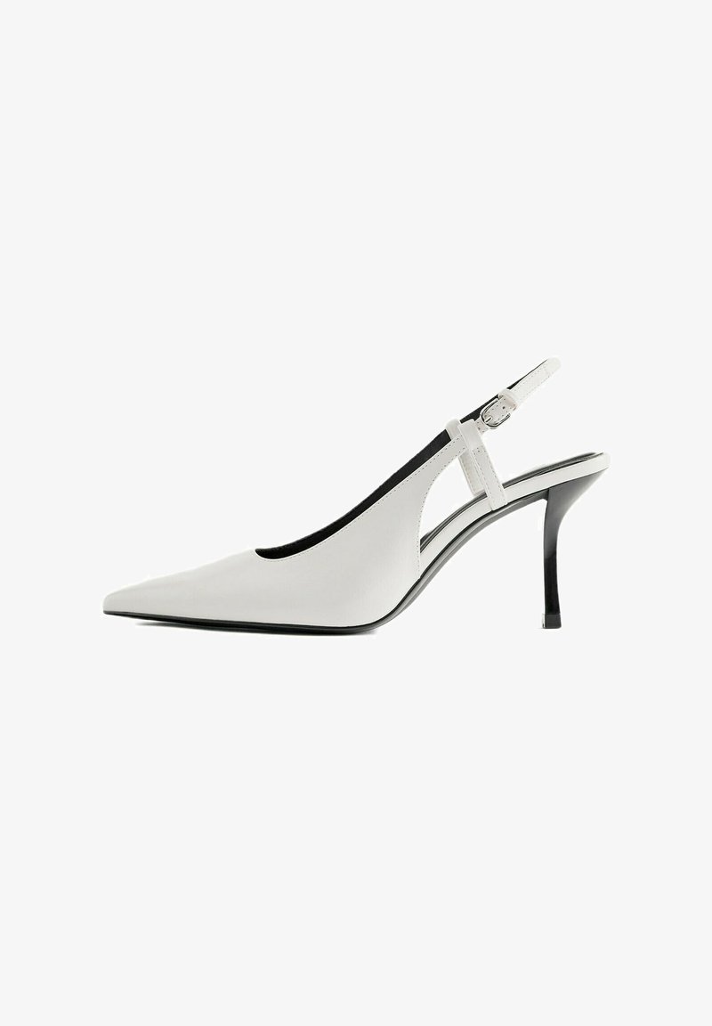 Chaussure blanche à talon haut et bout pointu, avec un talon fin noir et une bride de cheville réglable avec boucle.