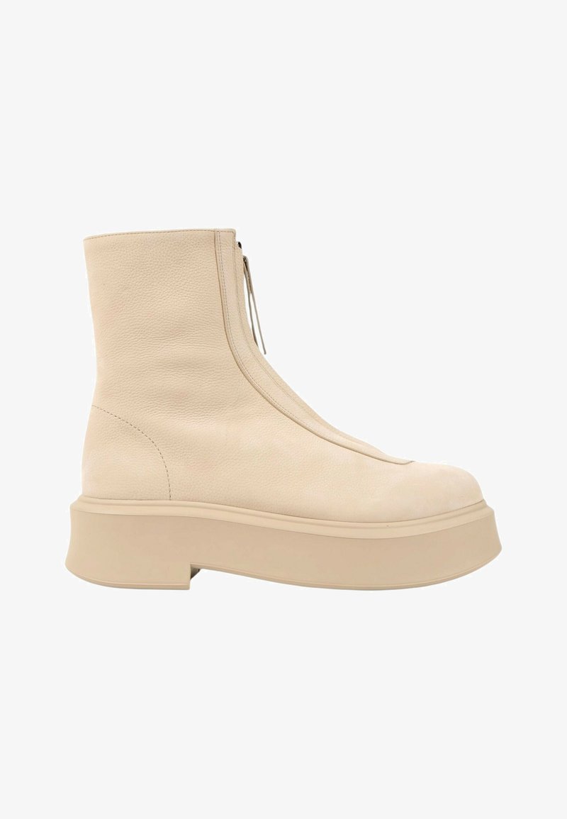 Bottine de couleur crème avec dessus en cuir lisse, fermeture éclair frontale et semelle plateforme épaisse.