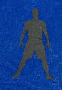 Silhuet af en person stående med benene fra hinanden og armene lidt væk fra kroppen på en tekstureret blå baggrund.