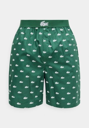 Dunkelgrüne Boxershorts mit elastischem Bund, versehen mit weißen Krokodillogos, die überall aufgedruckt sind, sowie einem größeren Krokodillogo am Bund.