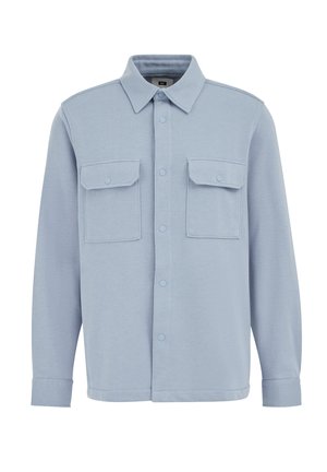 Világoskék ingdzseki, puha anyagból készült, gombbal záródó elülső résszel, két mellzsebekkel és sima textúrájú klasszikus gallérral.