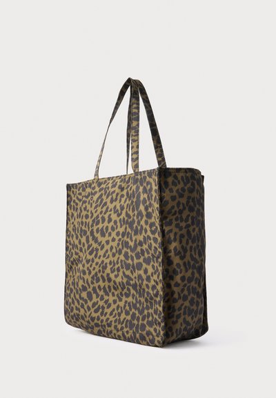 Sac fourre-tout rectangulaire avec de longues anses, présentant un motif léopard brun et noir sur un fond uni.