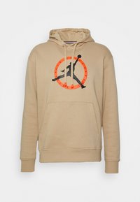 Sudadera con capucha beige con un logo negro de Jumpman en el centro dentro de un círculo naranja. Incluye un bolsillo canguro y capucha con cordón ajustable.