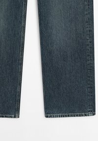 Donkerblauwe spijkerbroek met rechte pijpen en zichtbare stiksels langs de randen, weergegeven tegen een witte achtergrond.