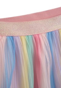 Gestufter Tüllrock mit einem weichen, rosa Bund. Er zeichnet sich durch Pastellfarben aus: Blau, Grün, Gelb, Rosa und Lavendel in einem Farbverlauf.