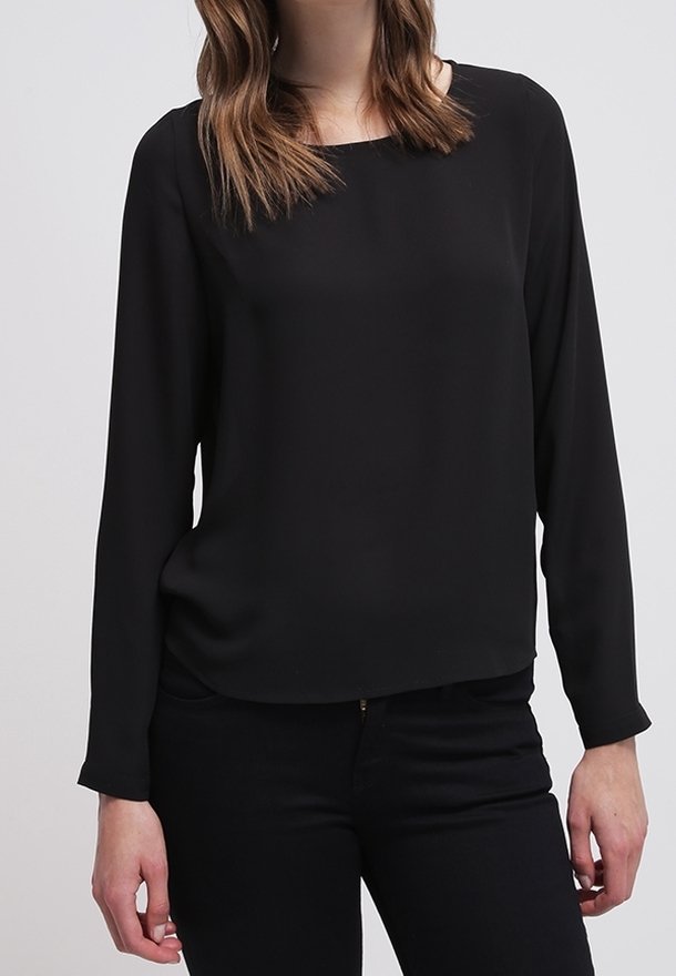 Svart långärmad blus med fyrkantig halsringning, tillverkad av ett mjukt tyg, med en avslappnad passform, bärs över mörka jeans.