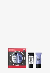 De Smashbox Test Shot Primer Duo bevat twee tubes: een zwarte primer en een lila primer in een rode camera-geïnspireerde doos met een ronde venster.