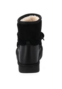 Stivale in suede nero con una morbida fodera color crema, parte superiore arrotondata, suola piatta e dettagli decorativi a strappo esterno.