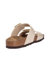 Sandalias beige con plantilla de corcho, que presentan dos correas anchas y una punta redondeada. Acentos en tono dorado realzan el diseño moderno.