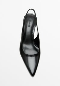 Svart lackläder slingback-klack med spetsig tå, med urtagna sidor och en slät yta. Varumärkeslogotyp präglad på innersulan.