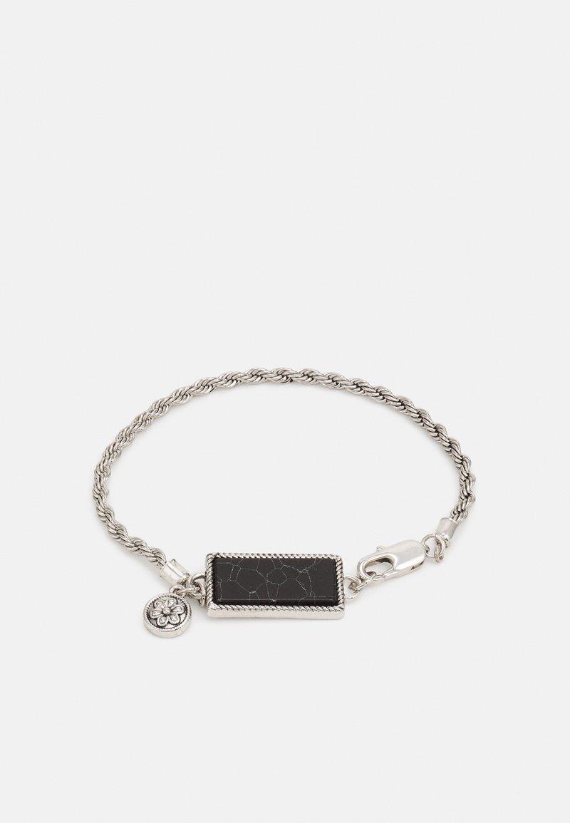 Stříbrný spirálový náramek s obdélníkovým černým kamenem s prasklinovou texturou a malým květinovým přívěskem.