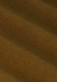 Tissu en feutre marron avec une texture douce, présentant un léger éclat et une surface légèrement nervurée, mettant en valeur des tons riches et chaleureux.