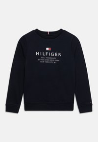 Granatowa bluza bawełniana z długimi rękawami i okrąg�łym dekoltem. Na przodzie znajduje się biały napis „HILFIGER” oraz logo. Ściągacze na mankietach i na dole bluzy.