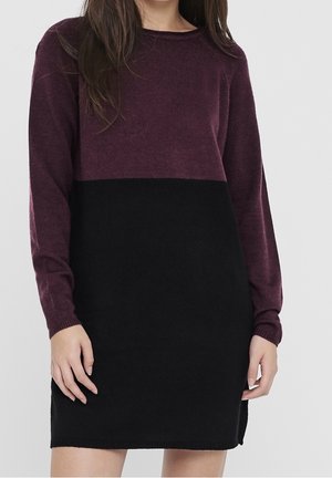 Bordeauxrotes und schwarzes Strickkleid mit lockerem Schnitt, langen Ärmeln und geripptem Halsausschnitt. Strukturierter Stoff mit Colorblock-Design.